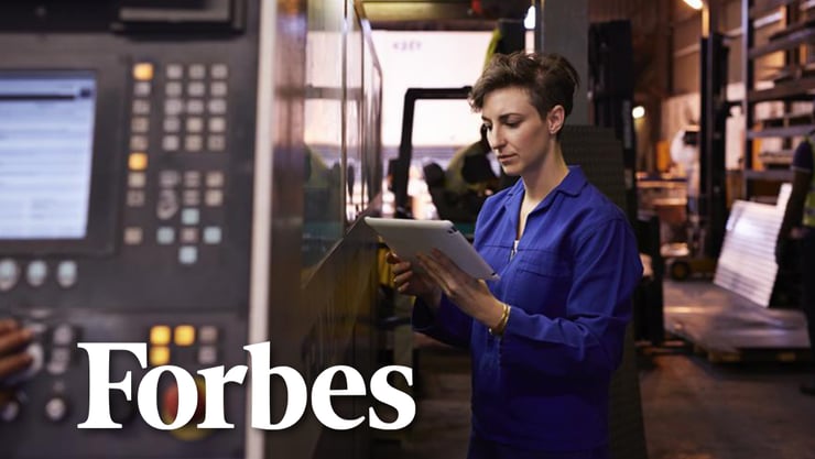 A woman looking at a tablet next to a large machine. The text reads, "Forbes."